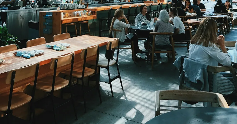 Guests dining at wooden tables in a restaurant