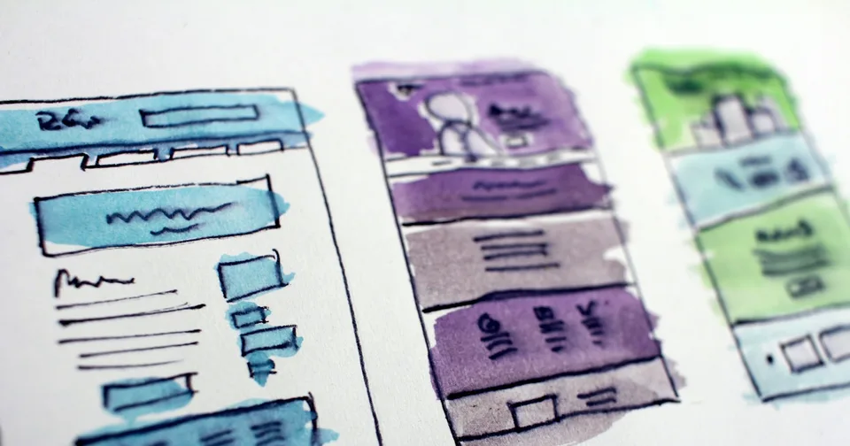 Website layout ideas drawn and coloured on paper