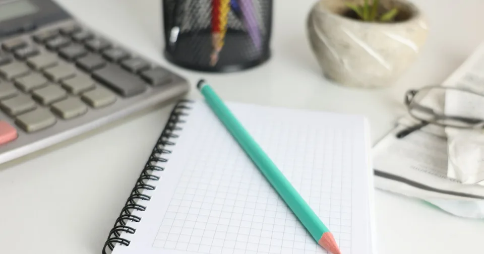 Calculator, notebook and pencil laid out for a project budget
