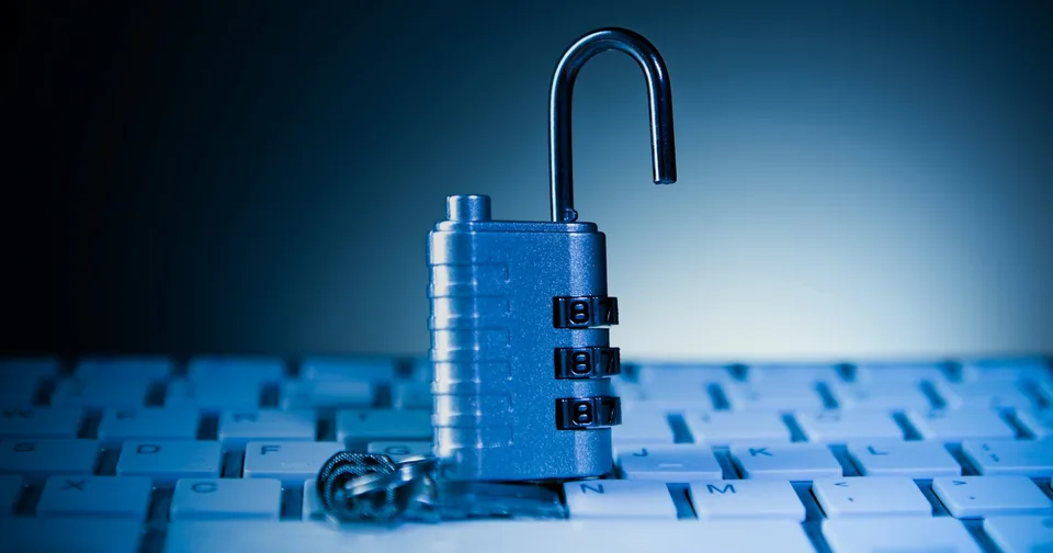 An open padlock resting on a computer keyboard